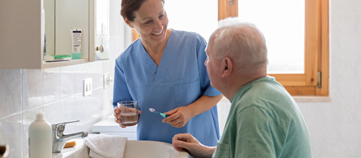 Caregiver explaining to a senior man the in-home care hygiene services that are provided.