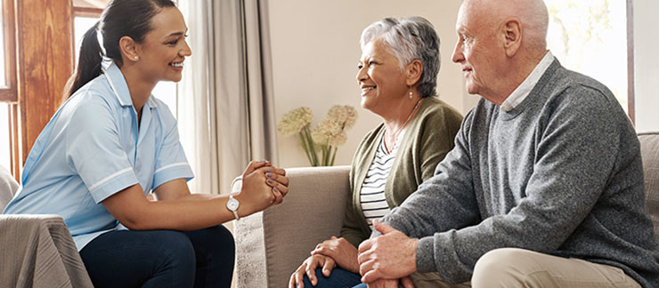 Home caregiver discusses different home care options with a senior couple.