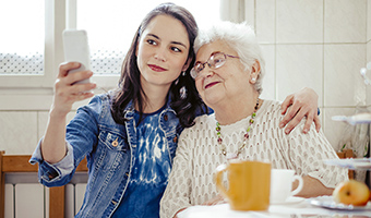 Millennial-aged female taking a selfie with her grandmother who she provides care.
