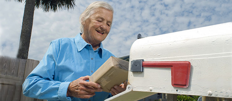 Senior receives medication at mailbox from a pharmacy delivery service.