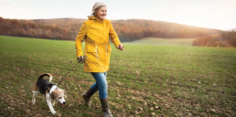 Woman in rainjacket walking dog.