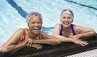 Smiling senior women enjoying the benefits of an indoor pool.
