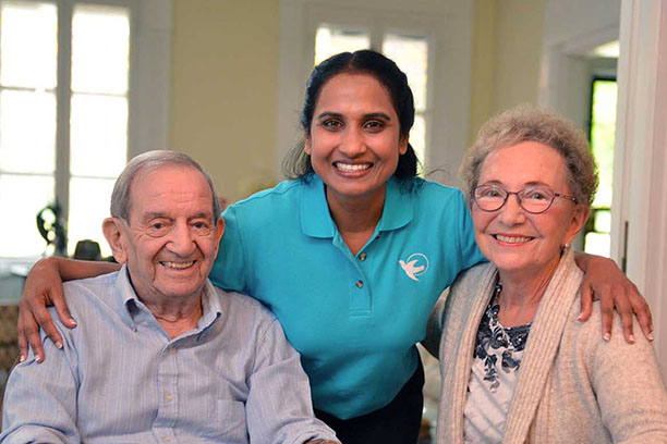 Caregiver with an elderly man and an elderly women.