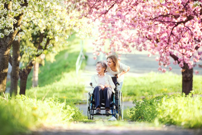 Caregiver walking outside with senior woman