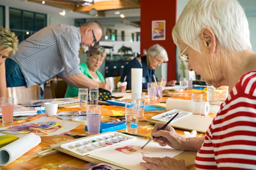 Eldelry woman painting with watercolors at a senior painting event
