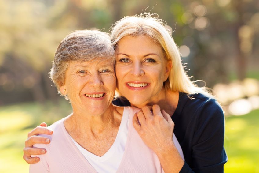 Adult daughter smiling with elderly mother