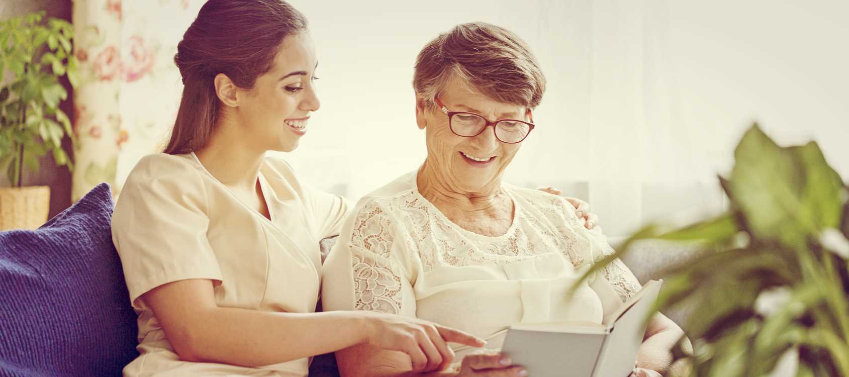 home care aide reading with an elderly client