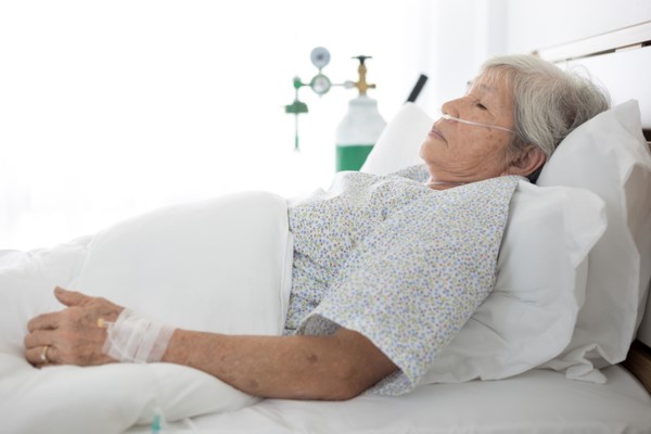 Elderly sick woman lying in bed