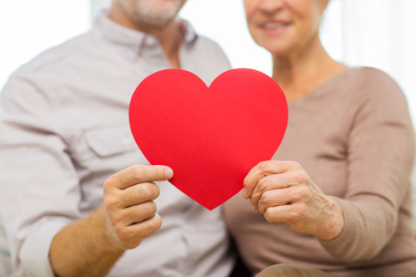 Elderly couple holding a paper Valentine's Day heart