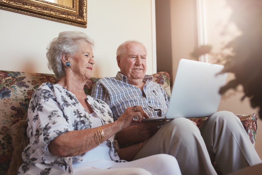 Elderly couple sitting together on the computer