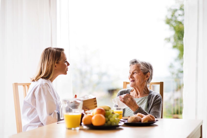 Adult daughter spending time with elderly mother outside