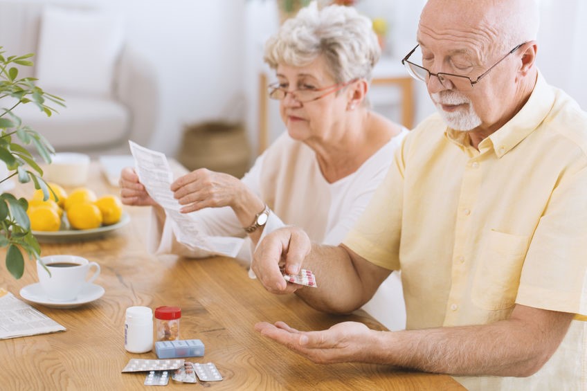 Elderly couple organizing daily medications
