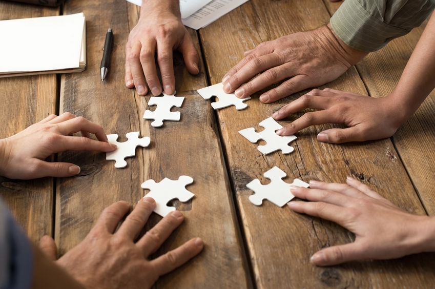 A group of people putting together a jigsaw puzzle