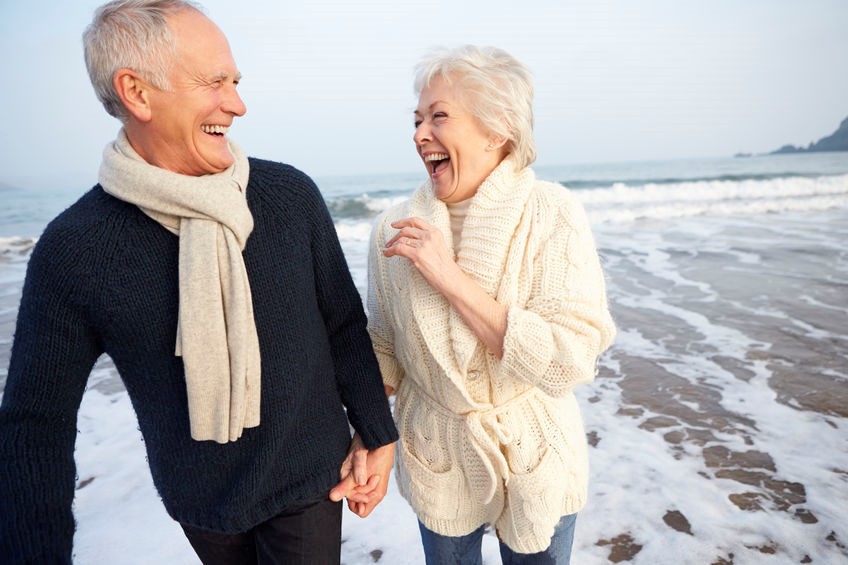Elderly couple walking together on a beach