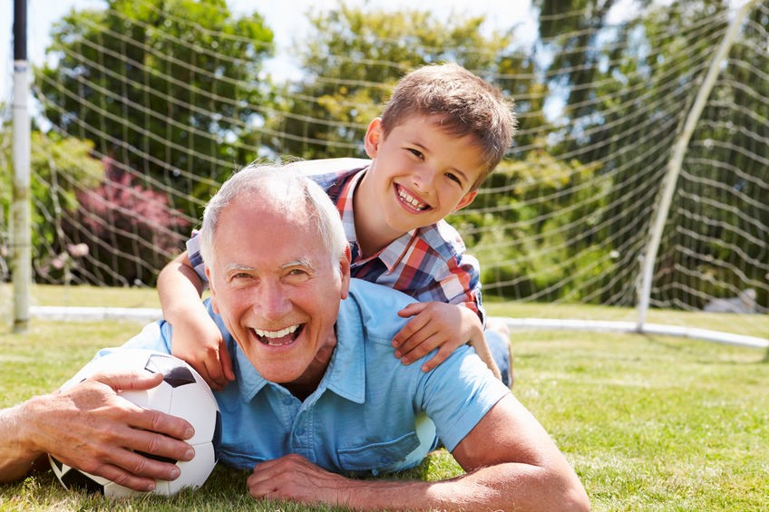 Grandfather playing soccer with grandson