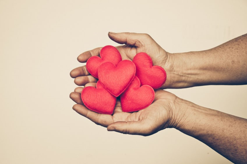 Pair of hands holding heart-shaped decorations