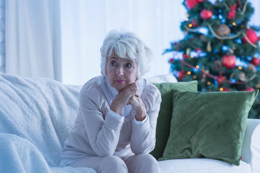 Concerned elderly woman sitting on couch