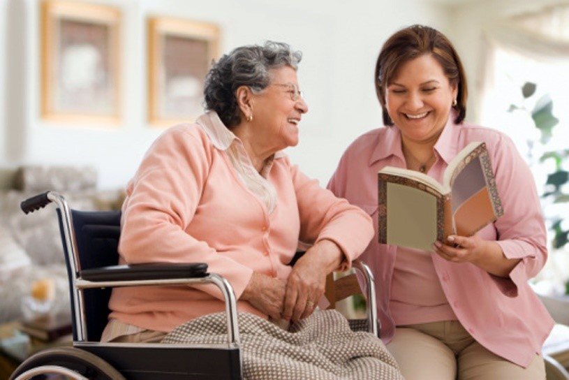 Home caregiver reading to senior with dementia