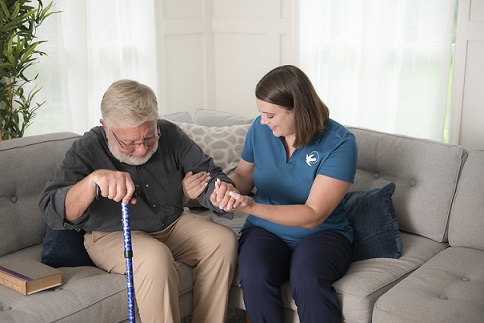 provider of home care in St. Peters assisting elderly patient on to couch