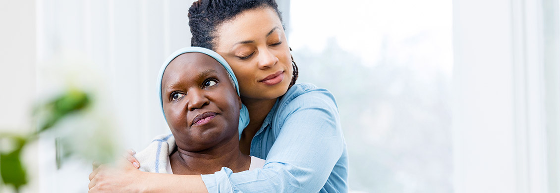 Caregiver providing compassionate end of life care with a loving hug to senior woman.