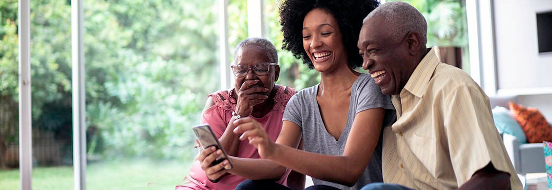 Caregiver provides long-distance care by connecting elderly couple to family via video phone call.