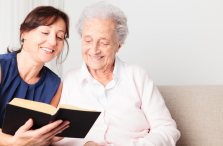 provider of elderly care in Fort Wayne looking at book with senior patient