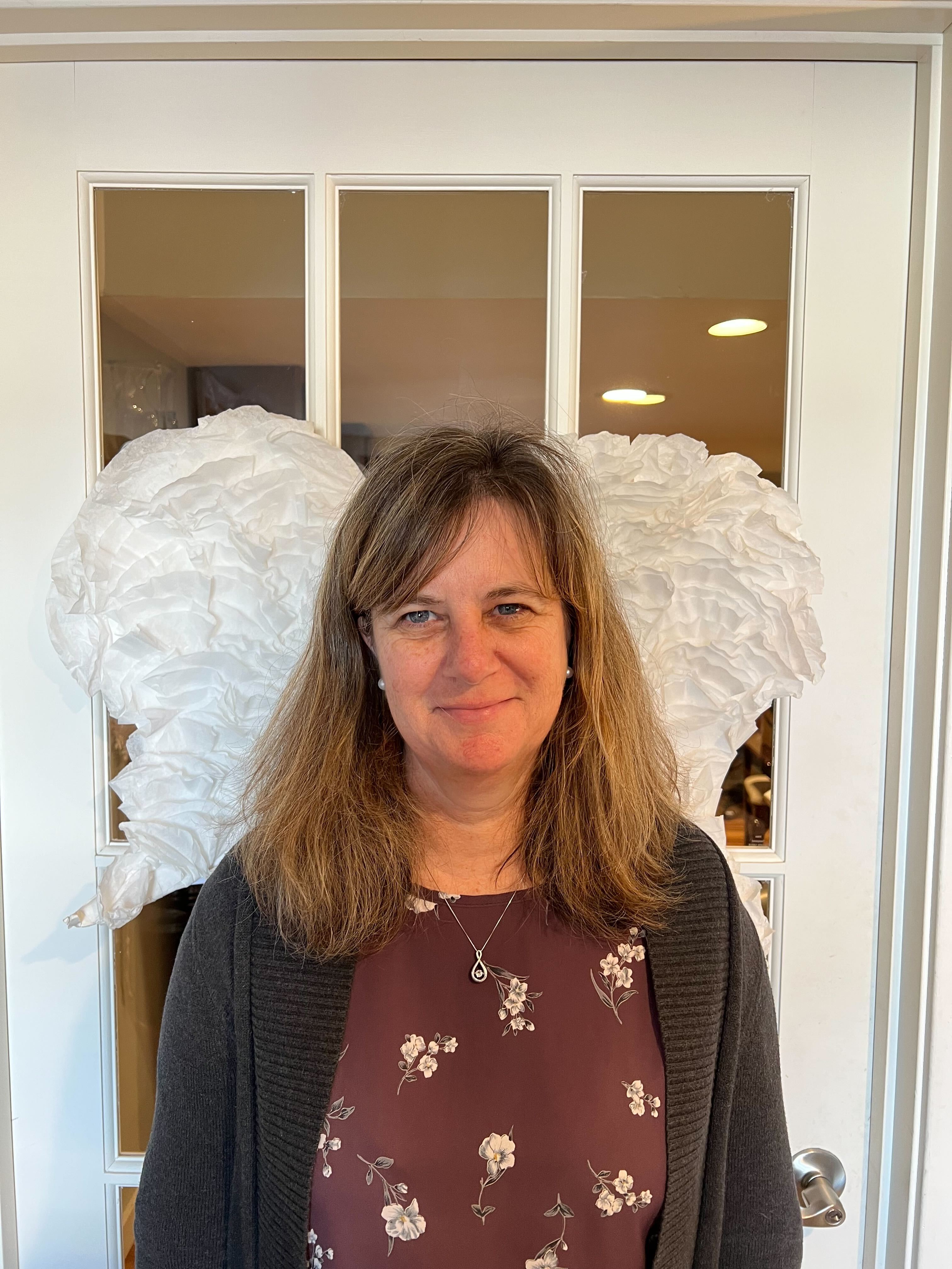 Carroll standing in front of angel wings
