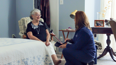 home care provider helps senior in bedroom