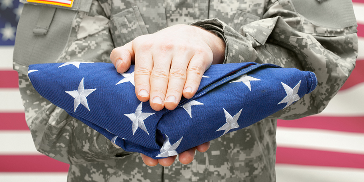 soldier presenting a folded flag