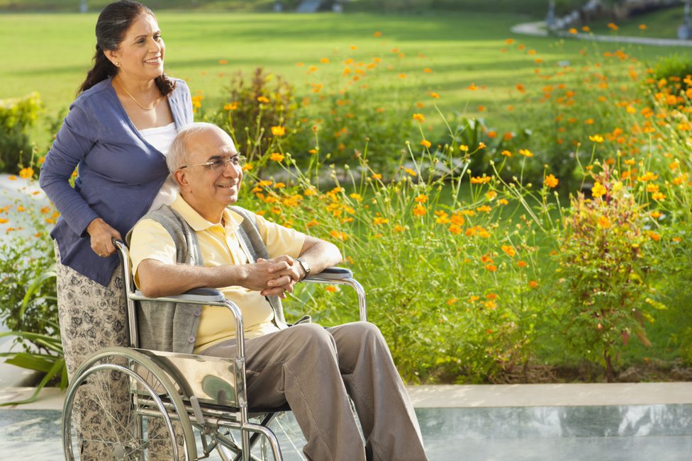 Home caregiver provides home care services to elderly man on wheelchair