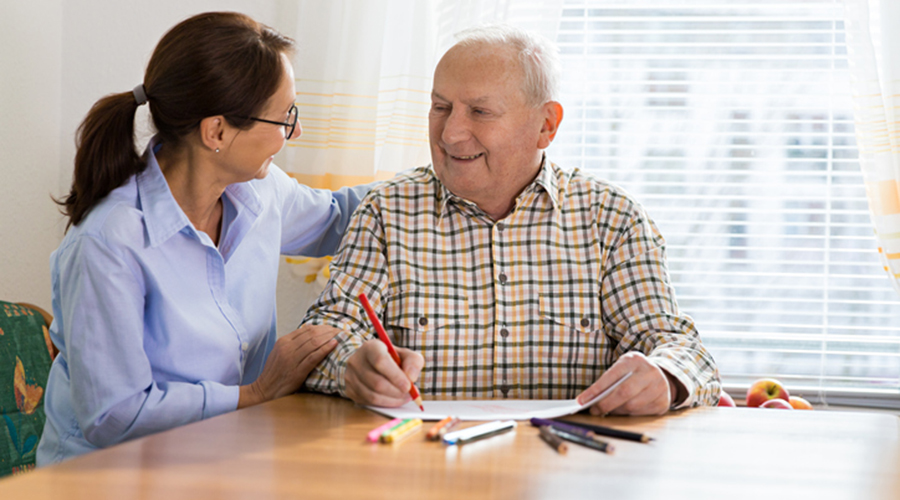 home care aide provides companionship to elderly man with Alzheimers