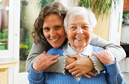 provider of living assistance in Midland hugging elderly woman