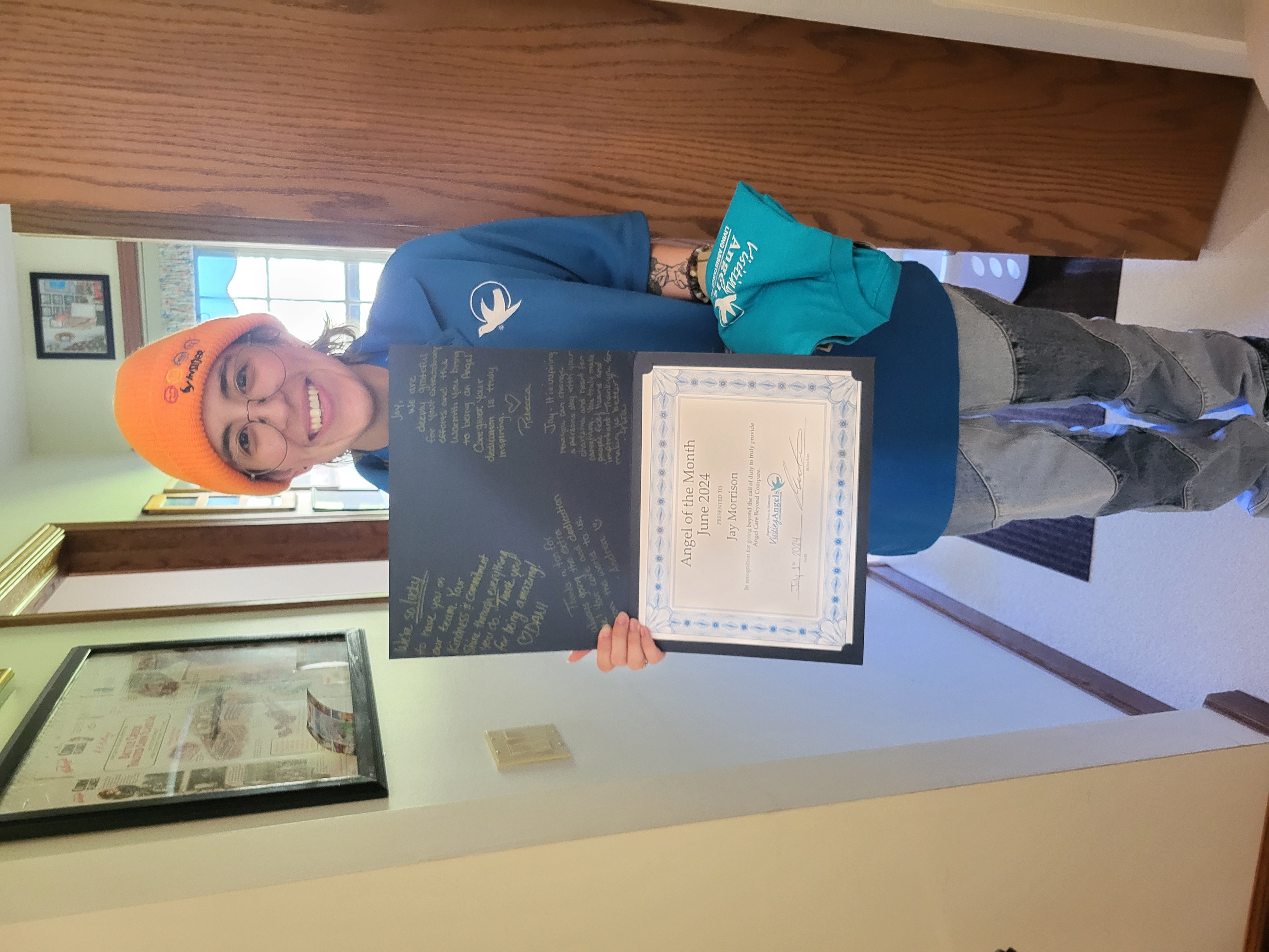 Jay Morrison smiles and shows their printed award for Angel of the Month for excellent caregiving in home care to clients in Allegan, Kalamazoo, Mattawan, Paw Paw, Plainwell, Portage, and Southwest Michigan.