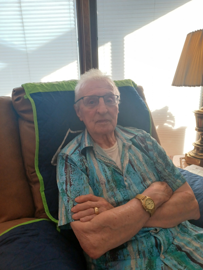 Visiting Angels of Spokane client in a blue Hawaiian shirt with a gold watch, sitting comfortably on a couch.