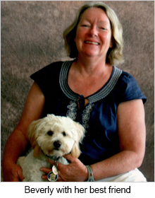 Woman seated with white dog in her arms